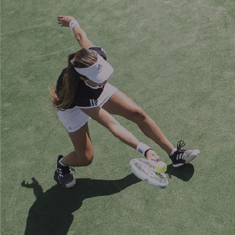 Picture of tennis player reaching to hit the ball.