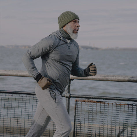 Picture of man jogging along a coastline.