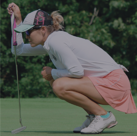 Picture of a golf player crouching next to her club looking stressed.