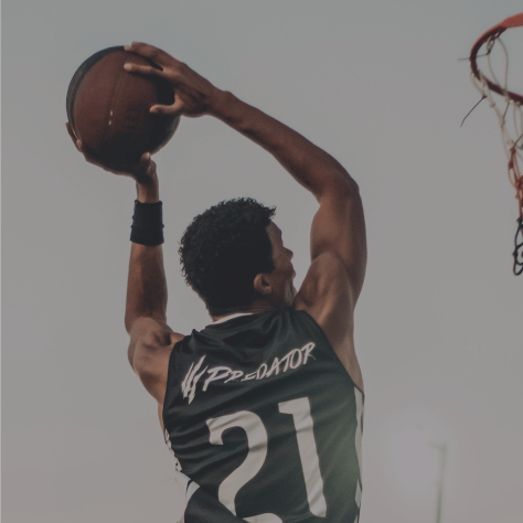 Picture of a basketball player mid-air about to dunk the ball.